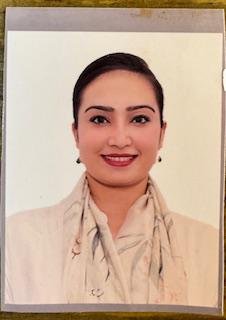 Portrait of Dr. Kapoor wearing traditional attire with academic books in background